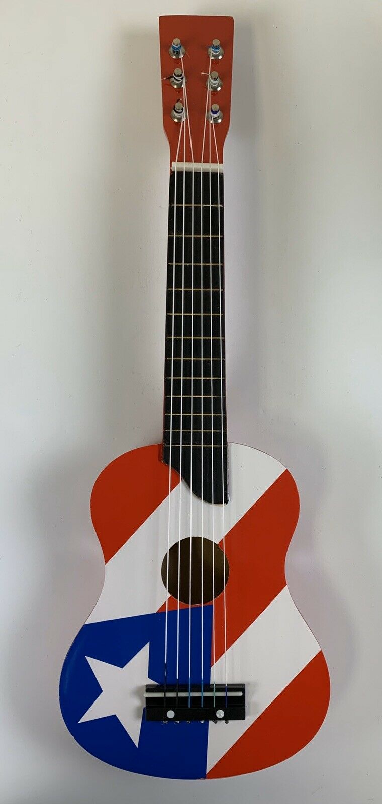 Small Guitar With Puerto Rico Flag Design. 23” X 7-1/2” X 2-1/4”.